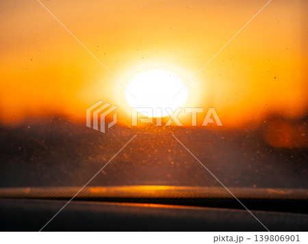 Bright sun with bokeh effect shining through a dusty car windshield. Golden hour light for sunrise or sunset imagery. Bright sun with bokeh effect shining through a dusty car windshield. Golden hour light for sunrise or sunset imagery. 139806901