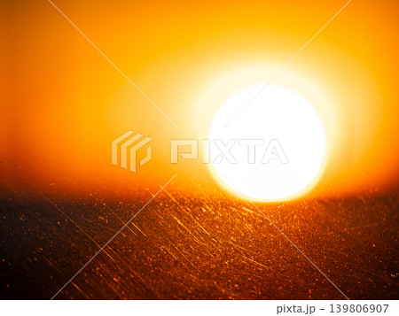 Bright sun with warm golden and orange light over abstract textured surface. Sunset or sunrise concept with glaring lens flare. Bright sun with warm golden and orange light over abstract textured surface. Sunset or sunrise concept with glaring lens flare. 139806907