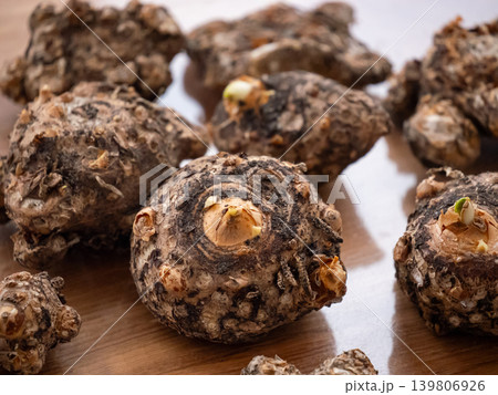 Close up of several turmeric rhizomes with new sprouts on a wooden surface. Fresh organic spice ready for planting or culinary use. Close up of several turmeric rhizomes with new sprouts on a wooden surface. Fresh organic spice ready for planting or culinary use. 139806926