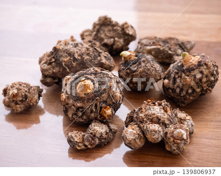 Several brown konjac plants with natural texture on a wooden table. Healthy Asian food ingredient for dieting and natural cooking concept. 139806937