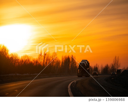Truck and cars drive on a winding road at sunset. Journey and travel concept for transportation marketing. Truck and cars drive on a winding road at sunset. Journey and travel concept for transportation marketing. 139806988