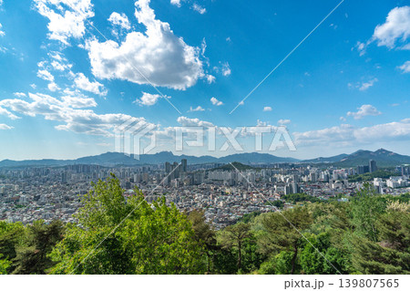 Beautiful spring afternoon cityscape of Seoul seen from Yongmasan Mountain with green trees and puffy clouds, South Korea Beautiful spring afternoon cityscape of Seoul seen from Yongmasan Mountain with green trees and puffy clouds, South Korea 139807565