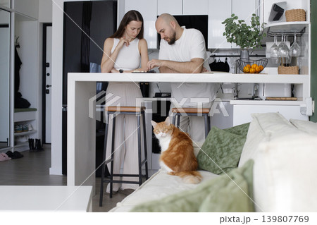 Cute family having fun together at home. Man and woman playing chess 139807769