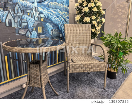 Rattan patio furniture set with glass table and wicker chair in showroom Rattan patio furniture set with glass table and wicker chair in showroom 139807833