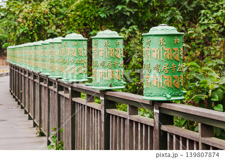 Green Prayer Wheels Along Wooden Temple Walkway Green Prayer Wheels Along Wooden Temple Walkway 139807874