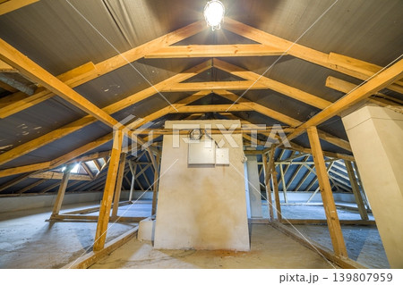 Attic of a building with wooden beams of a roof structure. 139807959
