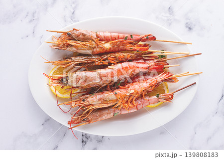 Freshly grilled prawns served, on a white platter ,with lemon slices for a delicious seafood experience 139808183