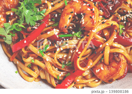 udon noodles, shrimp with vegetables and fresh herbs, in a bowl with chopsticks, light background, homemade, no people, 139808186