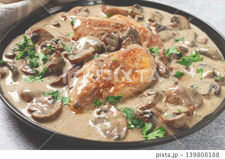 chicken in cream sauce with mushrooms, on a black plate, no people chicken in cream sauce with mushrooms, on a black plate, no people 139808188