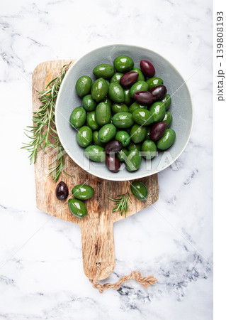 Chalkidiki olives, classic Greek green olives, in a bowl on a cutting board, top view, without people, 139808193