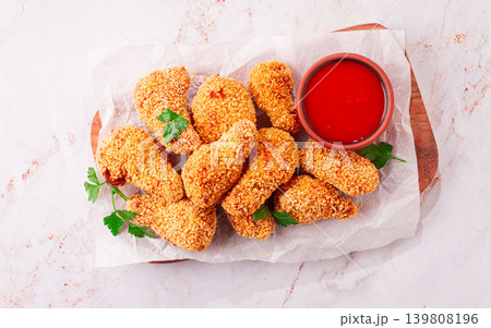 fried chicken legs in breadcrumbs, on a wooden chopping board, with red sauce, no people, fried chicken legs in breadcrumbs, on a wooden chopping board, with red sauce, no people, 139808196