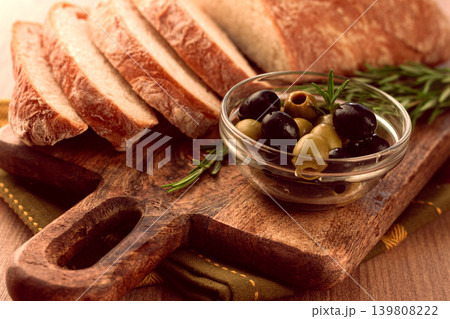 sliced ciabatta , on a chopping board, with rosemary and olives, Italian bread, close-up, Italian cuisine, breakfast, no people, sliced ciabatta , on a chopping board, with rosemary and olives, Italian bread, close-up, Italian cuisine, breakfast, no people, 139808222