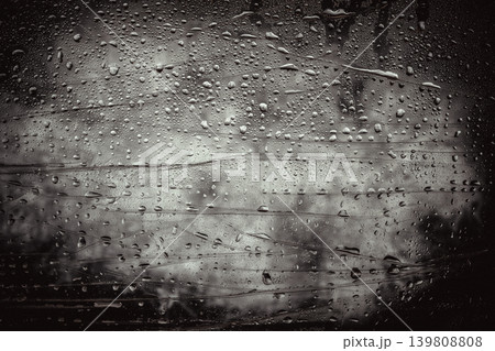 Dark rainy glass surface covered with water droplets, dramatic abstract texture. Concept of texture expressing moisture, melancholy mood, cinematic texture background, creative design, copy space Dark rainy glass surface covered with water droplets, dramatic abstract texture. Concept of texture expressing moisture, melancholy mood, cinematic texture background, creative design, copy space 139808808