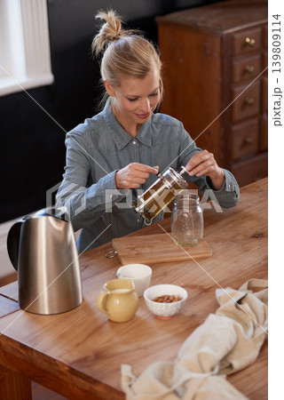 Woman, happy and tea of herbs in home and warm beverage of herbal mixture for health wellness. House, homeopath and detox with dry leaves in plunger and chamomile drink to relax in kitchen by table 139809114