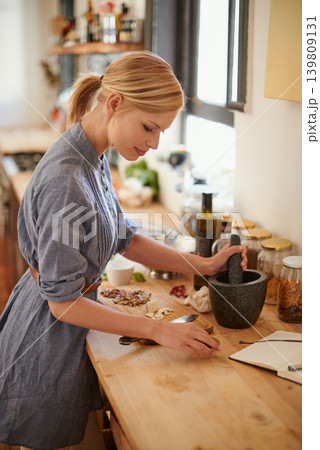 Cooking, woman and mortar with grind in a home with diet, nutrition and healthy food with pestle. Kitchen, bowl and happy from organic and vegan lunch with mushroom and wood board with wellness 139809131