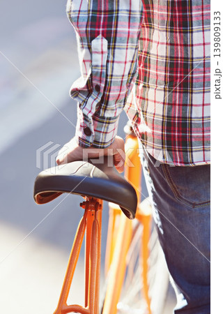 Hands, person and travel on bicycle in city on eco friendly transport outdoor, commute or walk. Cycling, back or push bike in urban town, street or road for journey with rear view of seat on sidewalk 139809133