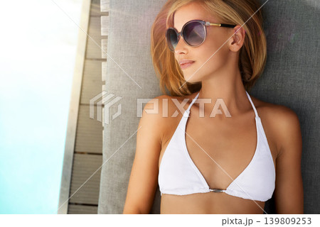 Woman, bikini and swimming pool or sunbathing in summer with sunglasses on patio furniture or holiday, vacation or rest. Female person, eyewear and water in Miami or travel, sunshine or stress relief Woman, bikini and swimming pool or sunbathing in summer with sunglasses on patio furniture or holiday, vacation or rest. Female person, eyewear and water in Miami or travel, sunshine or stress relief 139809253