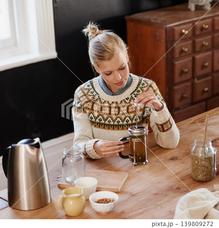 Woman, happy and herbal tea for wellness in home and warm beverage of herbs mixture for health. Kitchen, lady and detox with dry leaves in plunger and chamomile drink to relax in apartment in above 139809272