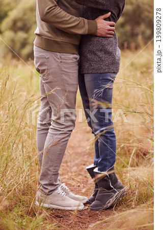 Love, legs and hug with couple in countryside together for romance, bonding or dating on field of grass. Nature, earth or environment with man and woman embracing outdoor for anniversary closeup Love, legs and hug with couple in countryside together for romance, bonding or dating on field of grass. Nature, earth or environment with man and woman embracing outdoor for anniversary closeup 139809278