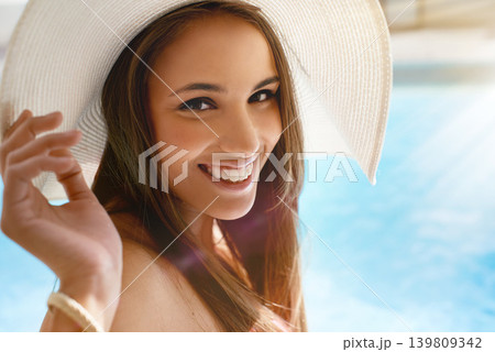 Smile, portrait and woman at swimming pool with hat, sunshine and and travel for summer holiday at hotel. Relax, water and face of happy girl on luxury vacation with adventure, weekend and fun in sun Smile, portrait and woman at swimming pool with hat, sunshine and and travel for summer holiday at hotel. Relax, water and face of happy girl on luxury vacation with adventure, weekend and fun in sun 139809342
