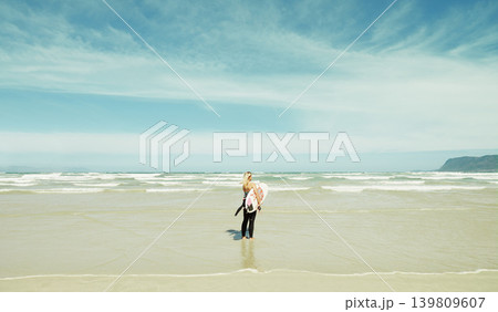 Beach, sky or space and woman with surfboard outdoor in summer for travel, sports or seascape view. Water, training and sand with surfer person by sea or ocean for fitness or exercise from back Beach, sky or space and woman with surfboard outdoor in summer for travel, sports or seascape view. Water, training and sand with surfer person by sea or ocean for fitness or exercise from back 139809607