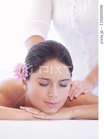 Relax, massage and woman at wellness spa with flower for health, rest and luxury holistic treatment. Self care, peace and girl on table with masseuse for body therapy, balance and calm hotel service 139809896
