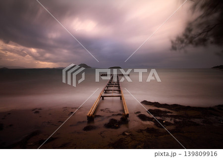old, rusty abandoned and dismantled pier. sky space is empty. suitable for writing. Seaside town of Turgutreis and spectacular sunshine. Long Exposure shoot. tranquility scene. 139809916