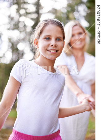 Girl, child and portrait outdoor with happiness for bonding, support or holding hands with mother on holiday in nature. Family, woman or daughter with face, smile or trust on vacation, travel or love 139810024