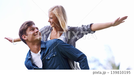 Couple, piggy back and plane with arms, smile or game by trees with care for connection with bonding outdoor. Man, woman and playful with airplane, wings or flight for freedom on journey for vacation 139810195