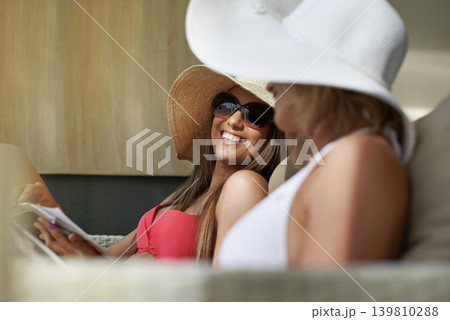 Friends, women and bonding or relaxing at hotel, getaway and resting on tropical vacation. Happy people, reading news and magazine for gossip on summer holiday, weekend trip and travel to resort Friends, women and bonding or relaxing at hotel, getaway and resting on tropical vacation. Happy people, reading news and magazine for gossip on summer holiday, weekend trip and travel to resort 139810288