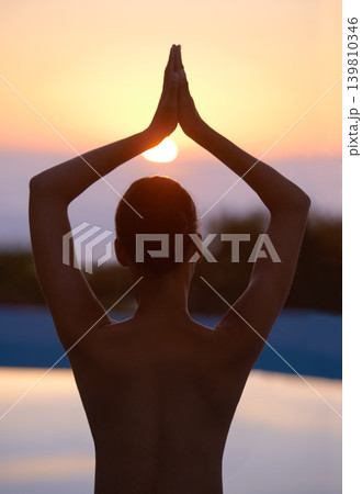 Tree, yoga and woman meditate at sunset by swimming pool for healthy body, wellness and zen outdoor. Rear view, vrikshasana pose and person at water at twilight to relax, peace or calm for balance Tree, yoga and woman meditate at sunset by swimming pool for healthy body, wellness and zen outdoor. Rear view, vrikshasana pose and person at water at twilight to relax, peace or calm for balance 139810346