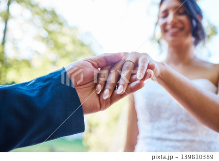 Love, wedding couple and holding hands with ring outdoor for commitment, loyalty and manicure. People, bride and groom with jewelry in nature for marriage partnership, union celebration and ceremony 139810389