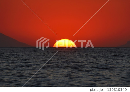 Close-up of empty sky and sun for copy space. The spectacular view of the sunset was breathtaking, with the sun sinking behind the clouds on the horizon. 139810540