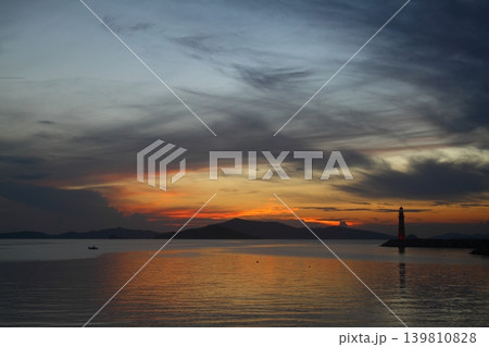 Seascape at sunshine. Lighthouse and sailings on the coast. Seaside town of Turgutreis and spectacular sunshine Seascape at sunshine. Lighthouse and sailings on the coast. Seaside town of Turgutreis and spectacular sunshine 139810828