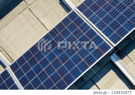 Aerial view of many photo voltaic solar panels mounted of industrial building roof. Aerial view of many photo voltaic solar panels mounted of industrial building roof. 139810877