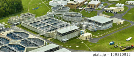 Aerial view of modern water cleaning facility at urban wastewater treatment plant. Purification process of removing undesirable chemicals, suspended solids and gases from contaminated liquid Aerial view of modern water cleaning facility at urban wastewater treatment plant. Purification process of removing undesirable chemicals, suspended solids and gases from contaminated liquid 139810913