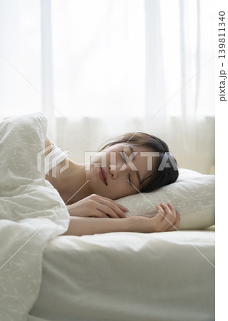 ベッドで眠る若い女性 寝顔 ベッドで眠る若い女性 寝顔 139811340