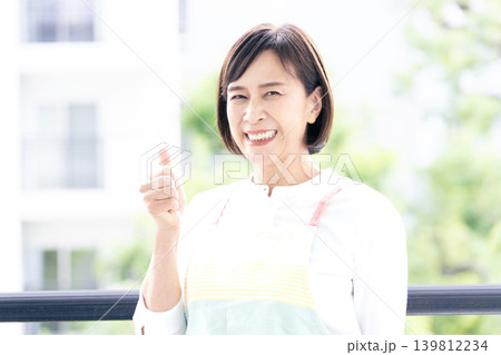 ベランダ掃除をするミドル女性 139812234