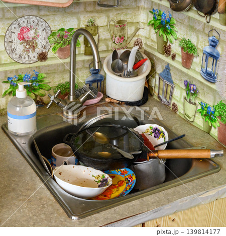 kitchen sink full of unwashed plates and pans 139814177