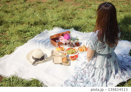 公園でピクニックを楽しむ女性の後ろ姿 139814513