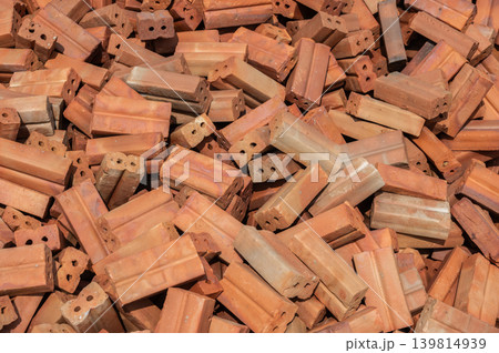 Pile of bricks before using for construction. Bricks are rectangular blocks of baked clay used for building walls, which are usually red or brown. 139814939