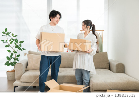 家で引越しの作業,梱包,荷造り,転勤,転居をする若いアジア人男女,夫婦,カップル 家で引越しの作業,梱包,荷造り,転勤,転居をする若いアジア人男女,夫婦,カップル 139815315