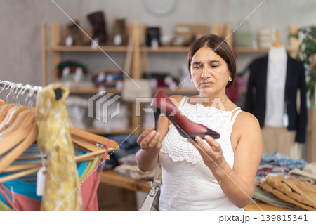 Latin woman customer turn over and choose high heels shoes in store 139815341