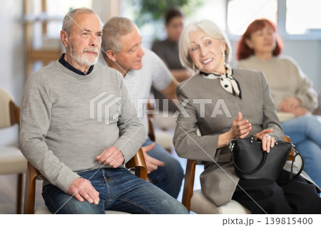 Portrait of an mature man listening attentively to a lecturer in group among other elderly people 139815400