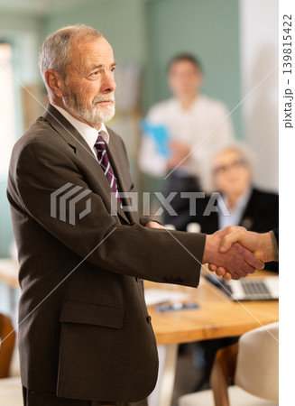 Senior men participants of meeting end business negotiations with handshake Senior men participants of meeting end business negotiations with handshake 139815422