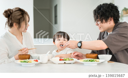 食卓で男の子にご飯を食べさせる父親 139815687