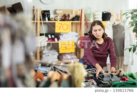 Selective Latina woman choosing jersey in clothing store Selective Latina woman choosing jersey in clothing store 139815766