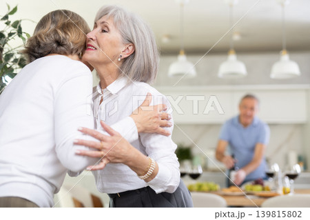 After chatting and gatherings, two mature women friends hug and kiss goodbye. After chatting and gatherings, two mature women friends hug and kiss goodbye. 139815802