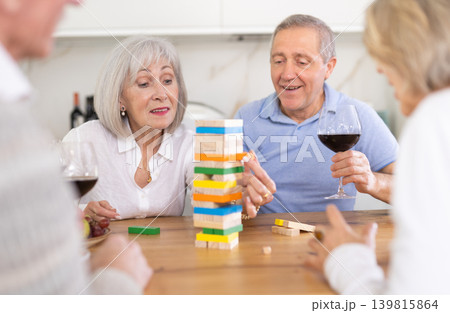 Couples of elderly women and men playing bricks Couples of elderly women and men playing bricks 139815864