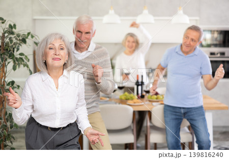 Senior men and women have fun dancing during house party. 139816240